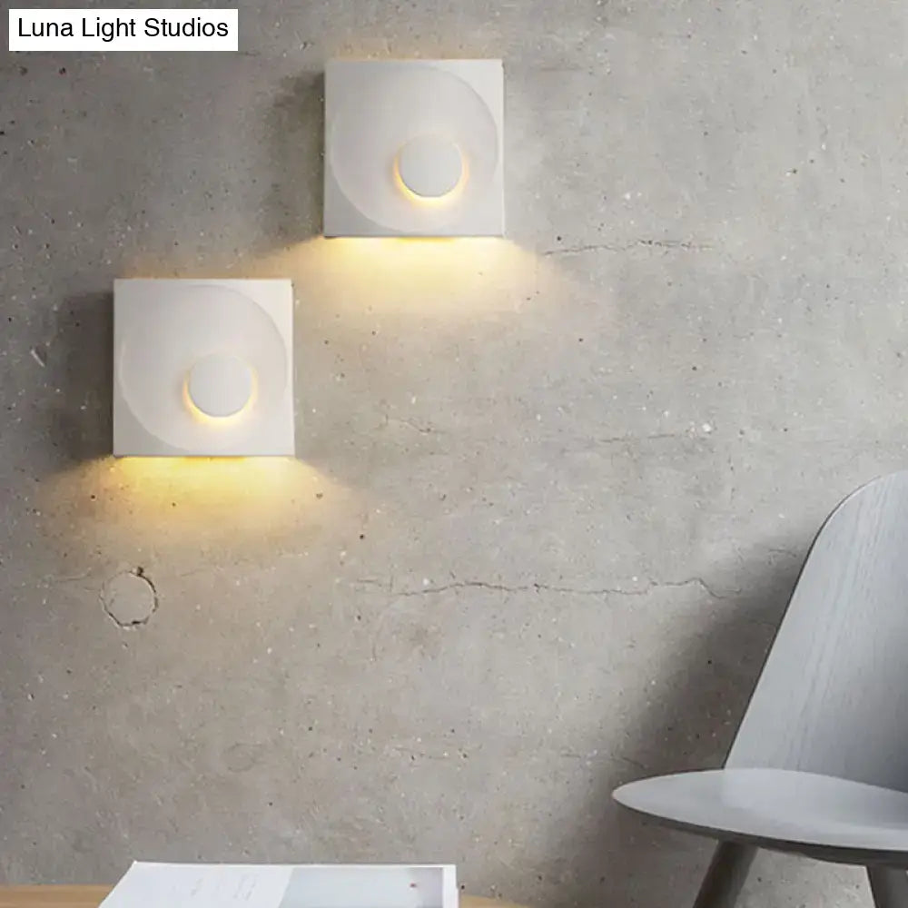 Modern black and gold cement square wall light with minimalist circular design emitting warm ambient light type for bedroom