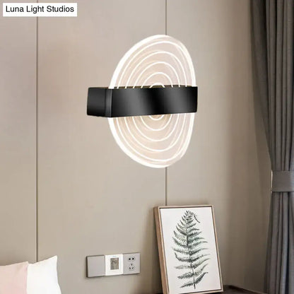 Modern black and gold wall lamp with concentric led rings emitting soft white glow, an ideal choice for living room