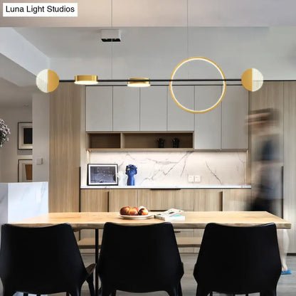DecorBites™ contemporary gold LED pendant light with circle metal island design above wooden dining table