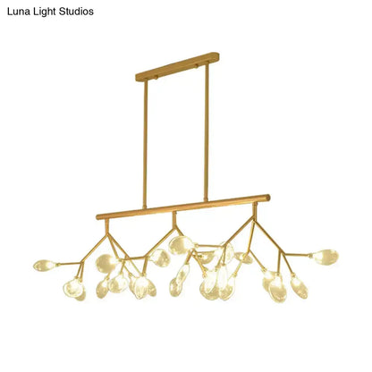 Modern black and gold chandelier with gold-toned branches and clear glass teardrop shades for dining room lighting