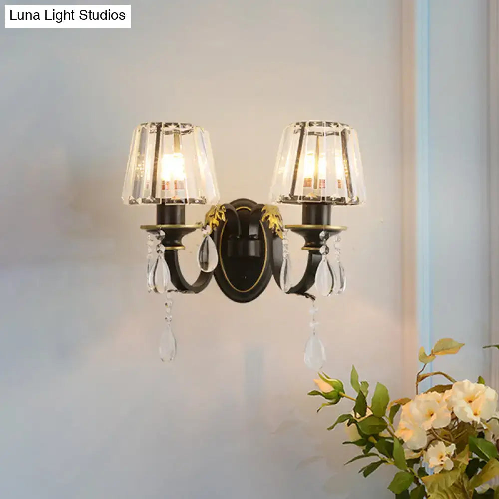 Elegant black and gold two-light wall lamp featuring conical crystal shades with dangling teardrop crystals for living room