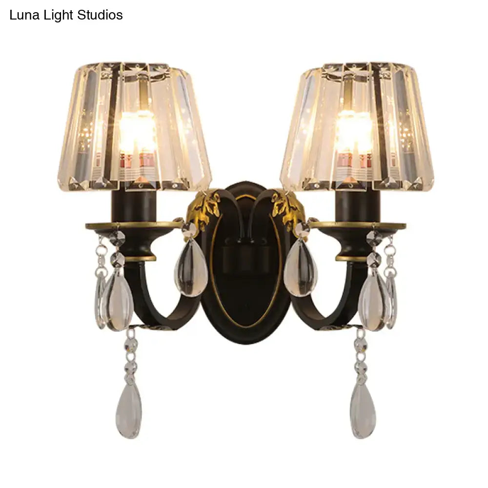 Elegant black and gold conical crystal wall lamp with faceted shades and dangling teardrop crystals for living room use