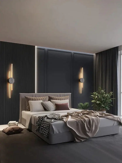 Modern gray upholstered bed with tufted headboard and layered bedding featuring modern black and gold decorbites copper wall light sconce