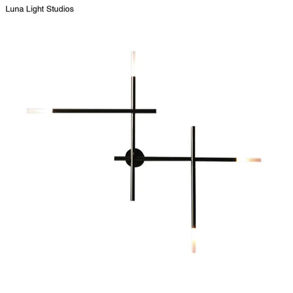 Modern black and gold wall light with crossed lines and frosted glass light fixture for bedroom illumination