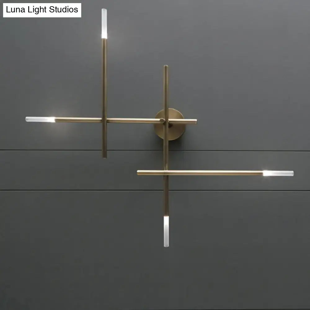 Modern black and gold brass wall light with minimalist crossed lines and integrated led light fixture for bedroom