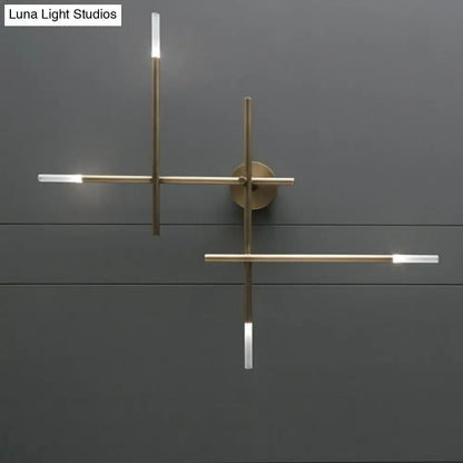 Modern black and gold brass wall light with minimalist crossed lines and integrated led light fixture for bedroom