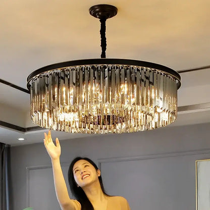 Modern black and gold pendant light with metal finish and cascading crystal prisms on a chain pendant for dining rooms
