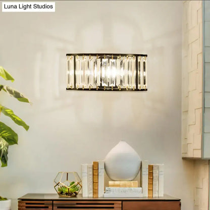 Modern black and gold crystal half cylinder wall sconce with clear crystal half bars in dark metal frame for bedroom lighting