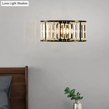 Modern black and gold crystal half cylinder wall sconce with clear crystal half rods emitting warm led glow for bedroom light
