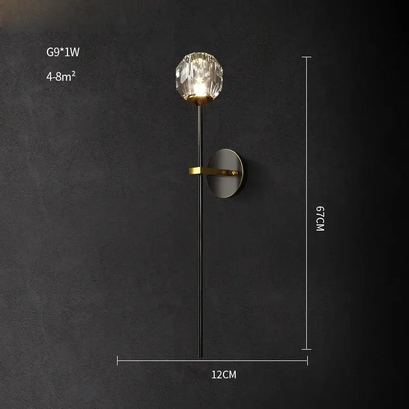 A sleek black wall sconce with gold-toned base and crystal globe, a decorbites crystal led wall light for bedrooms