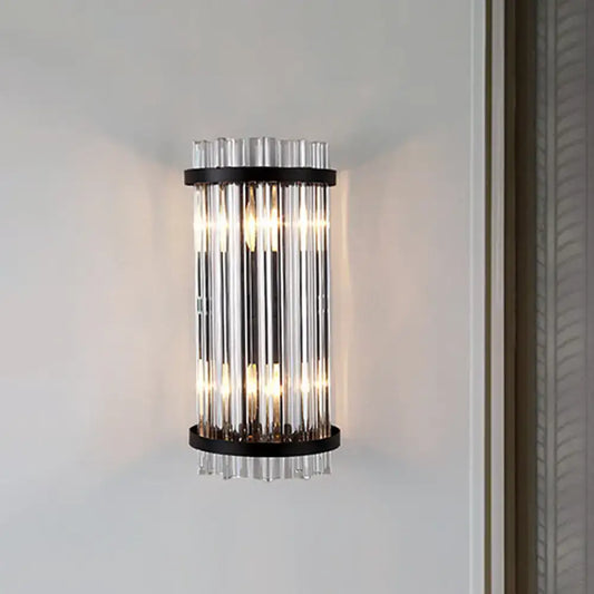 Modern black and gold crystal rod cylinder wall sconce featuring vertical clear glass tubes framed by black metal rings