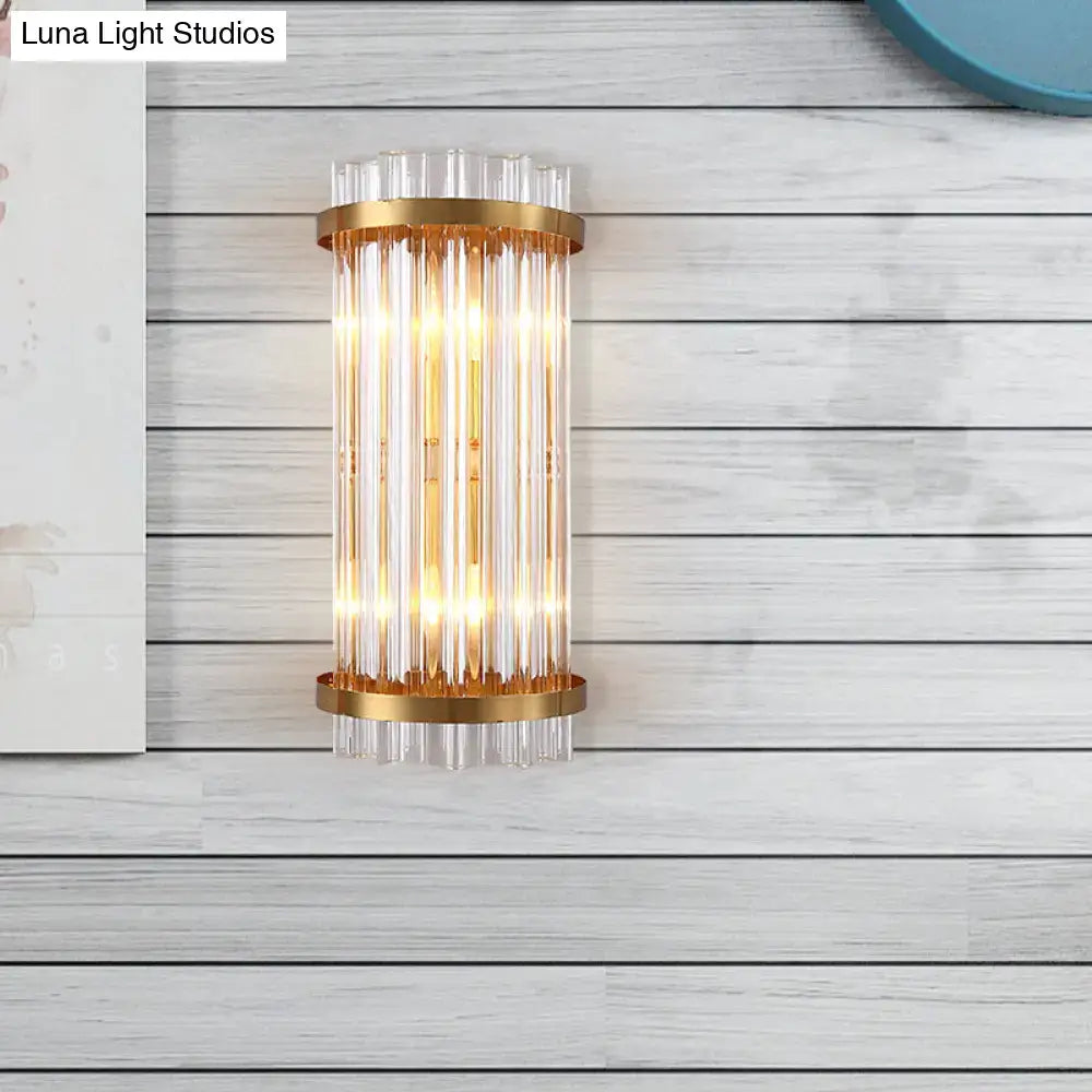 Gold-toned modern wall sconce with black accents and vertical clear crystal rods for bedroom lighting