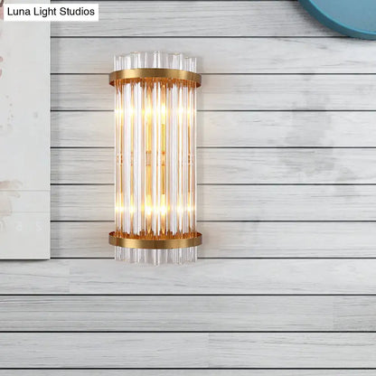 Gold-toned modern wall sconce with black accents and vertical clear crystal rods for bedroom lighting