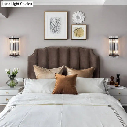 Brown tufted velvet headboard with nailhead trim paired with modern black and gold crystal rod cylinder wall sconce for bedroom lighting
