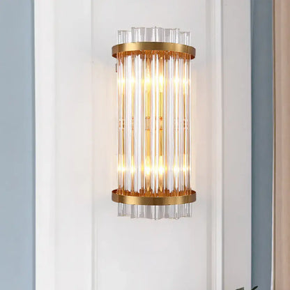 Modern black and gold crystal rod cylinder wall sconce with vertical clear glass rods and polished gold metal rings
