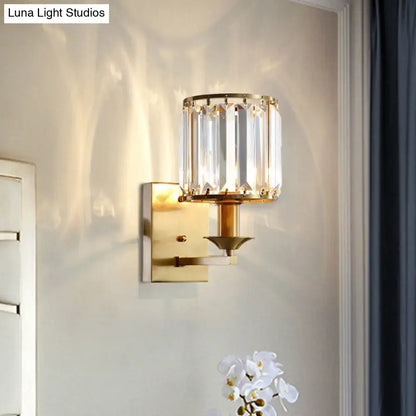 Modern black and gold sconce light fixture with cylindrical crystal shade and vertical faceted glass panels direct wired electric