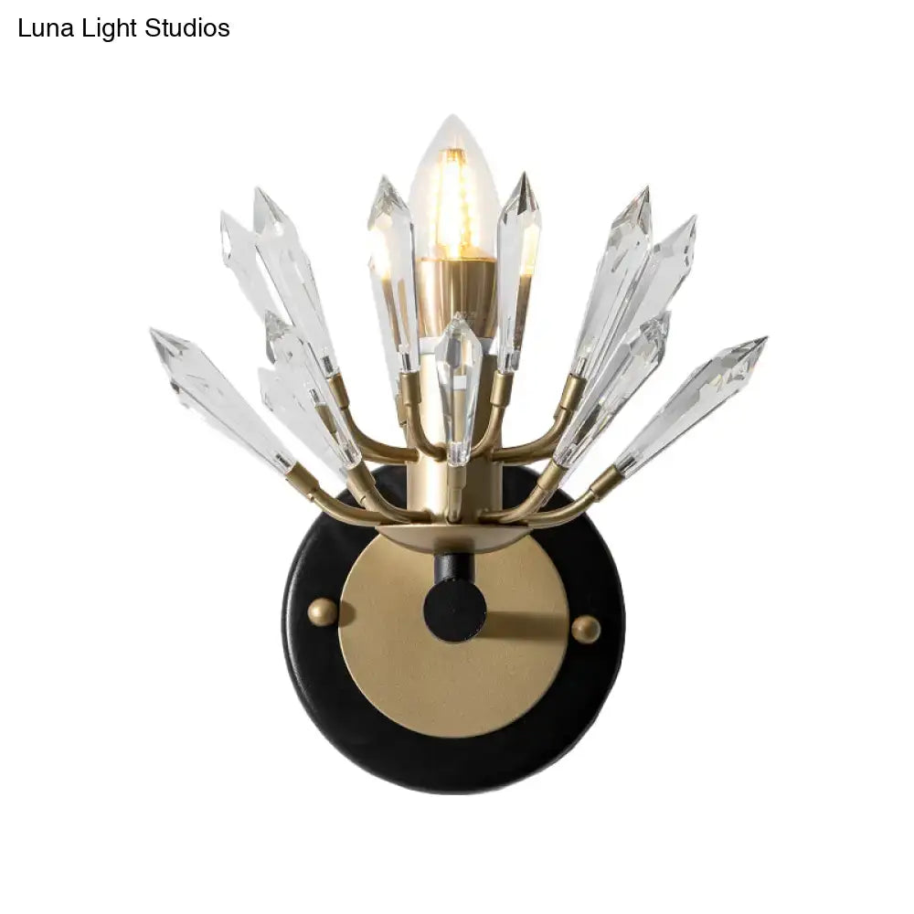 Modern black and gold crystal sconce light with brass fixture and clear prisms on a black circular base for living rooms