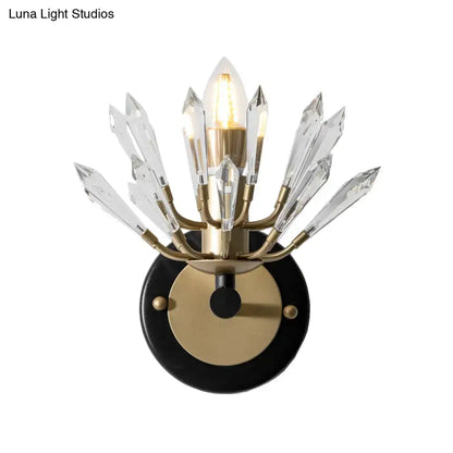 Modern black and gold crystal sconce light with brass fixture and clear prisms on a black circular base for living rooms