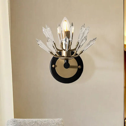 Modern black and gold crystal sconce light with brass base and clear crystal prisms for living room wall lamp