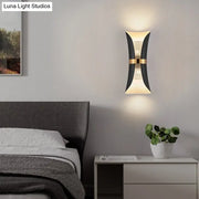 Modern black and gold curved wall lamp with sleek design ideal for bedroom lighting and decor