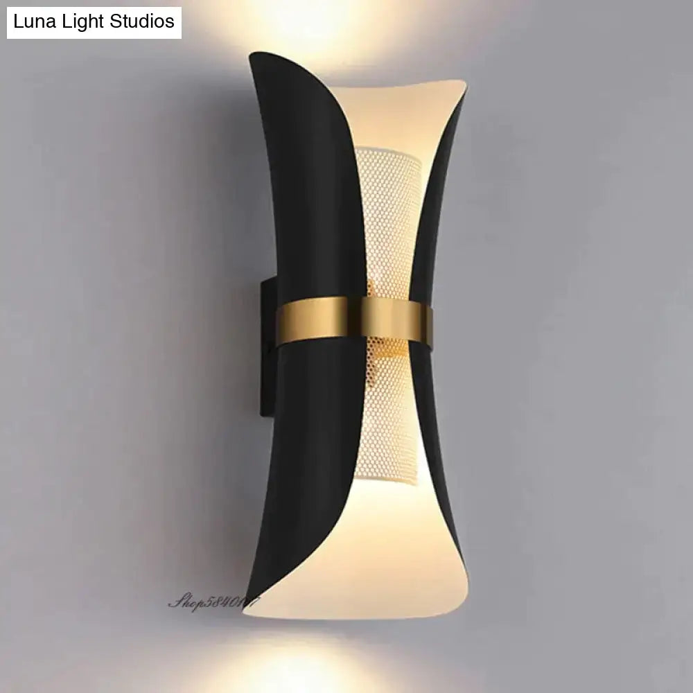 Modern black and gold curved wall lamp with frosted glass panels featuring a sculptural design for bedroom use