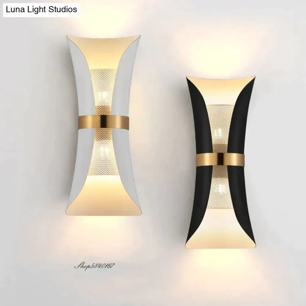Modern black and gold curved wall lamp with sleek white and black finishes accented by gold metal bands for bedroom use