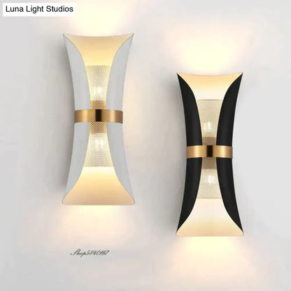 Modern black and gold curved wall lamp with sleek white and black finishes accented by gold metal bands for bedroom use