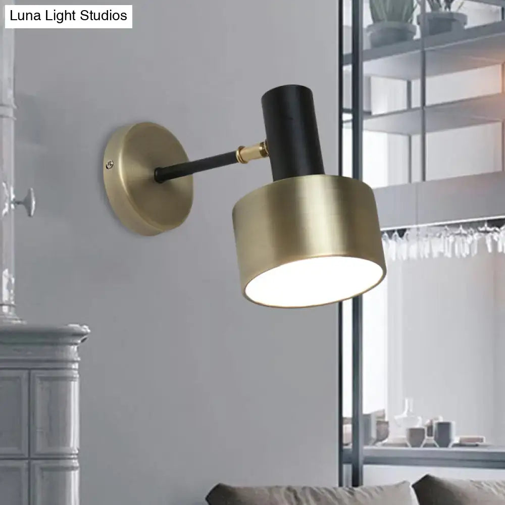 Modern black and gold cylinder sconce with matte black metal wall lighting and brushed brass accents for living room use