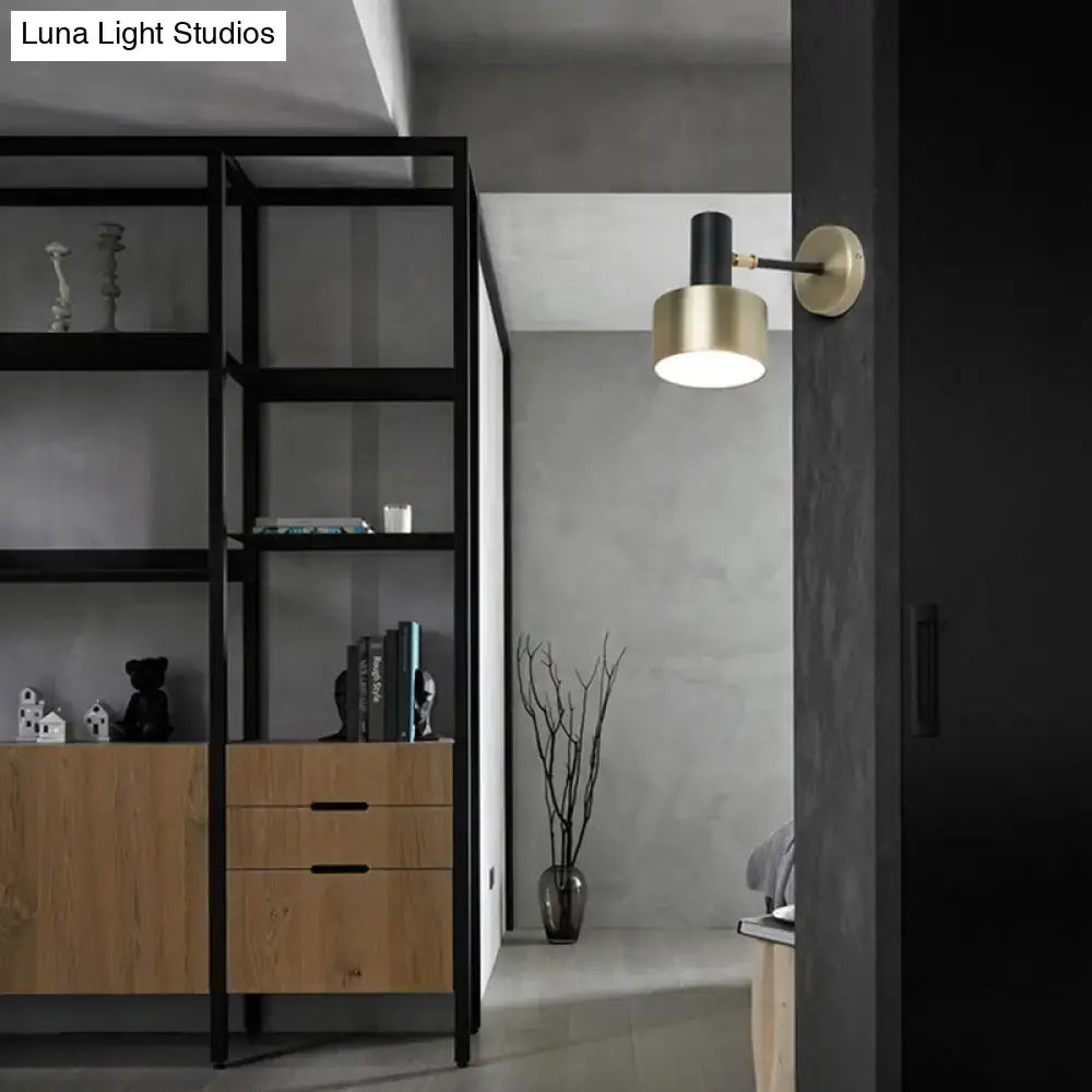 Modern brass and black metal wall lighting with a gold cylinder sconce ideal for living room use