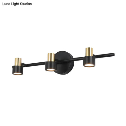 Modern black and gold cylinder wall light with three adjustable spotlights for bedroom vanity use