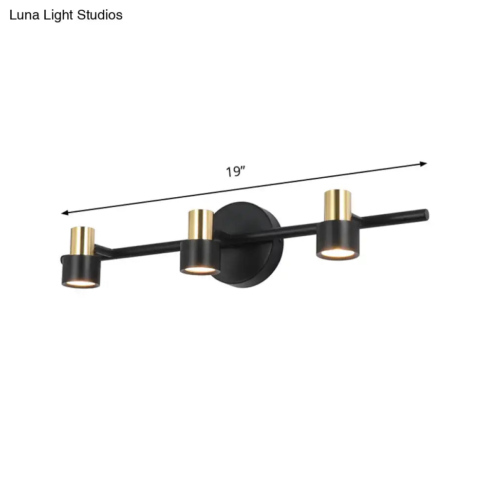 Modern black and gold three-light cylinder wall light with sleek minimalist design for bedroom vanity use