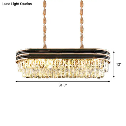 Decorbites™ elliptical pendant lamp in gold tone with black metallic bands and cascading clear crystal prisms for island lighting