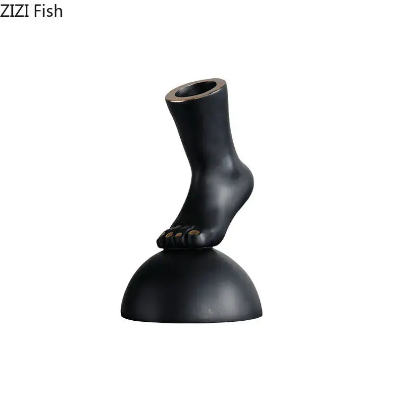 Modern black resin foot statue artwork with gold-toned toenails for living room decor and contemporary design