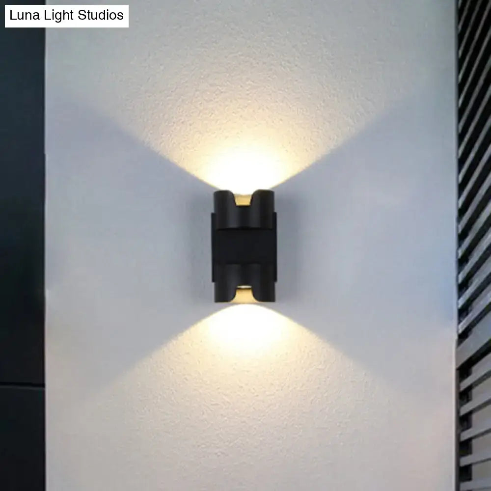Modern black and gold geometric led flush mount wall light with angled lights casting warm illumination for patio use