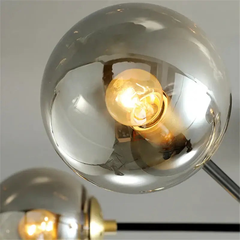 A warm glowing filament bulb inside a reflective chrome glass ball led chandelier for modern living room decorbites glass ball