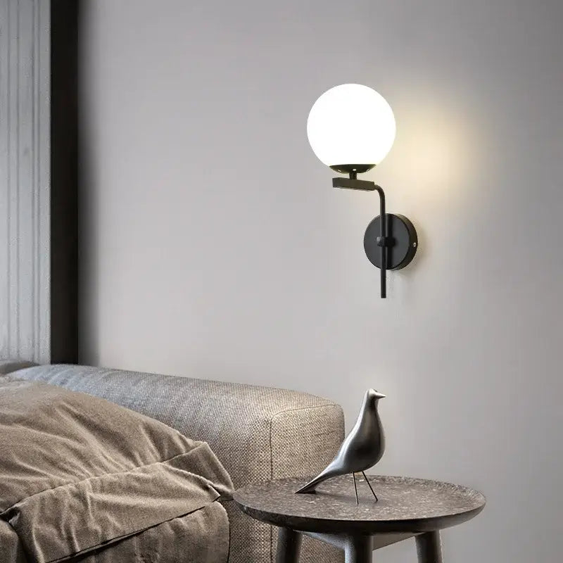 Modern black metal wall lamp with frosted glass ball led shade by decorbites for stylish bedroom sconce lighting