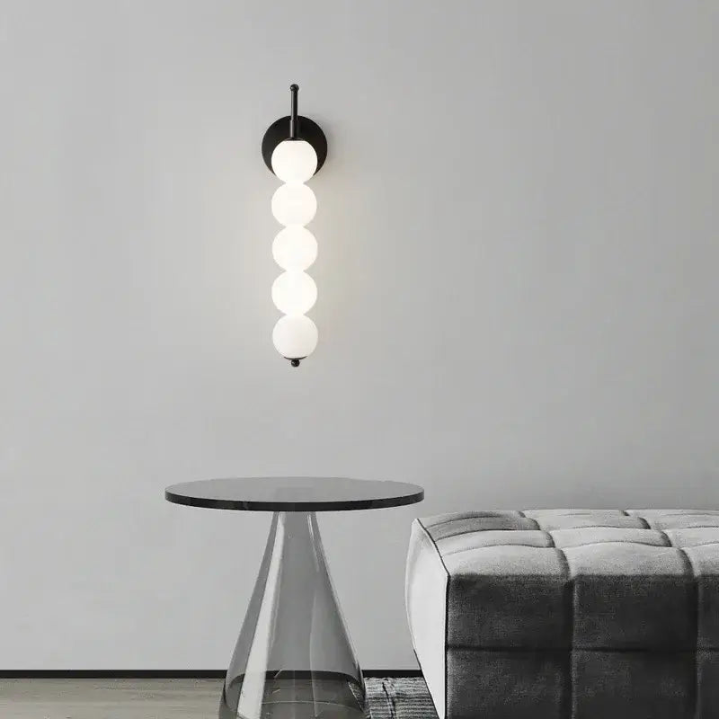 Modern black and gold glass bedside led wall lamp with five illuminated white glass spheres for bedroom decorbites wall lamp