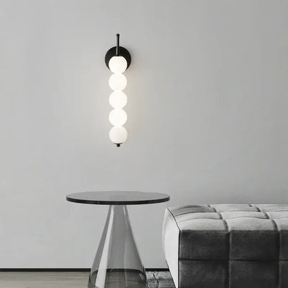 Modern black and gold glass bedside led wall lamp with five illuminated white glass spheres for bedroom decorbites wall lamp