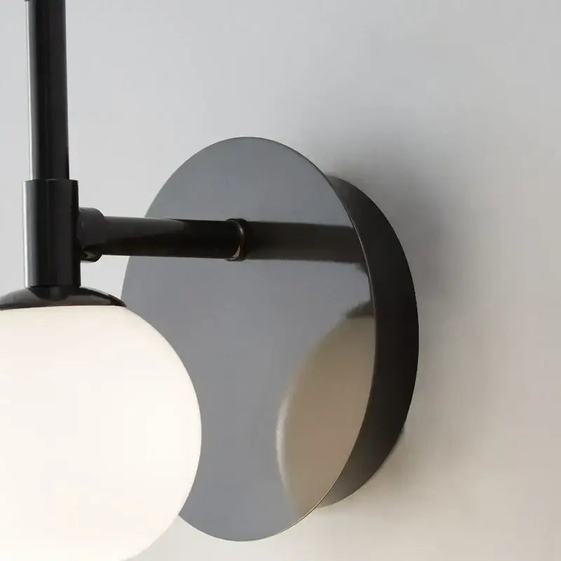 Modern black metal wall lamp with matte circular base and off-white glass bedside led shade for bedroom decorbites glass bedside