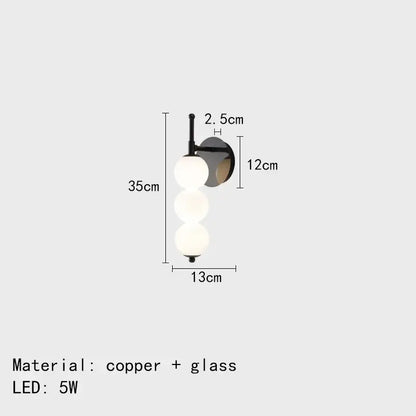 Modern black and gold glass bedside led wall lamp with three frosted glass spheres on a sleek copper arm decorbites glass bedside wall lamp