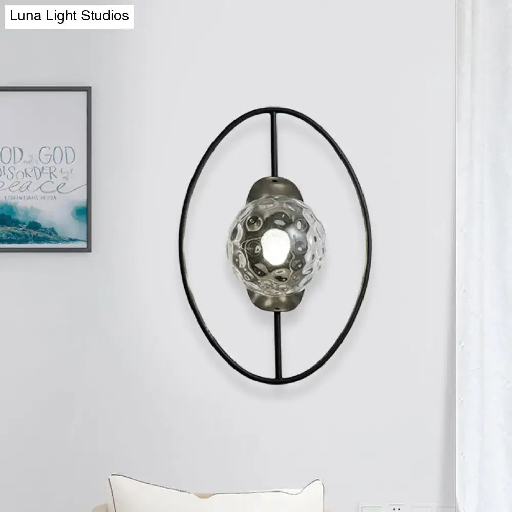 Modern black metal oval frame wall lamp with textured clear glass globe diffuser for bedroom fixture type