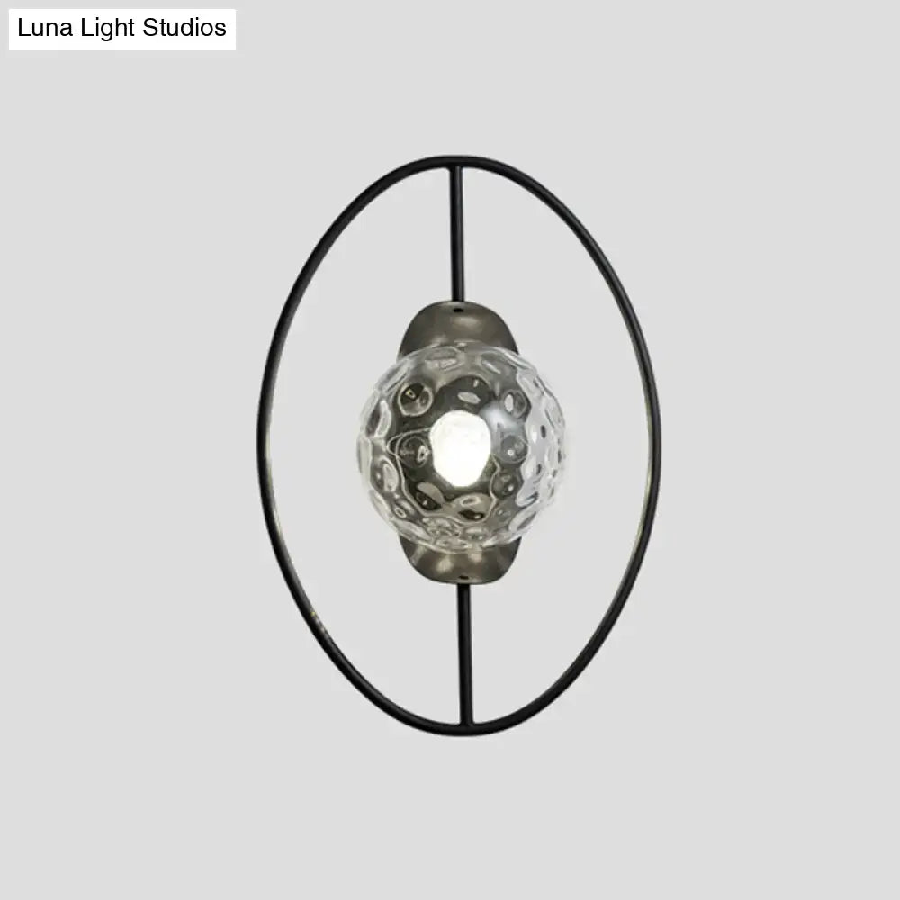 Modern black metal oval frame wall lamp with textured clear glass globe featuring intricate bubble pattern fixture type