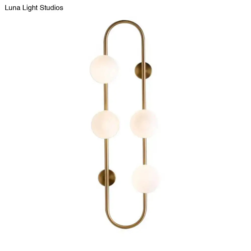 Modern black and gold globe wall sconce with brass finish and white glass globe shades for bedroom lighting