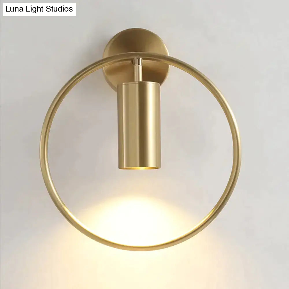 Brass-finished circular wall sconce with cylindrical light fixture modern black and gold irwin wall lamp for bedroom use