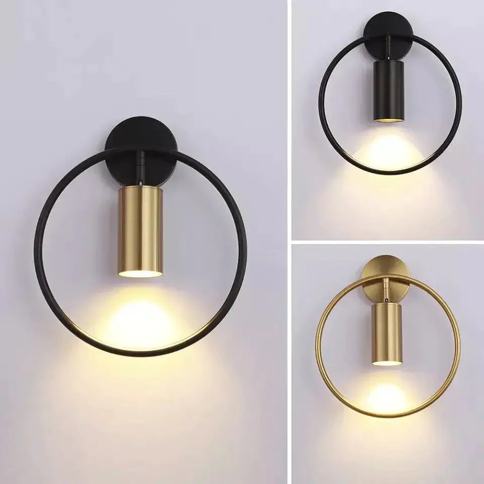 Modern black and gold irwin wall lamp features a circular wall sconce with a sleek cylindrical light fixture