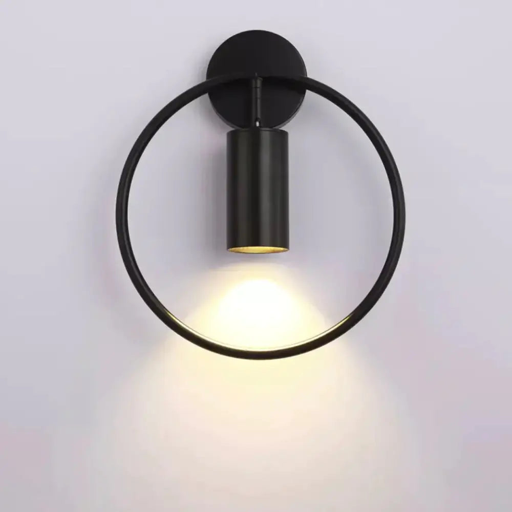 Modern black and gold irwin wall lamp with matte black circular sconce and illuminated cylindrical light fixture for bedroom