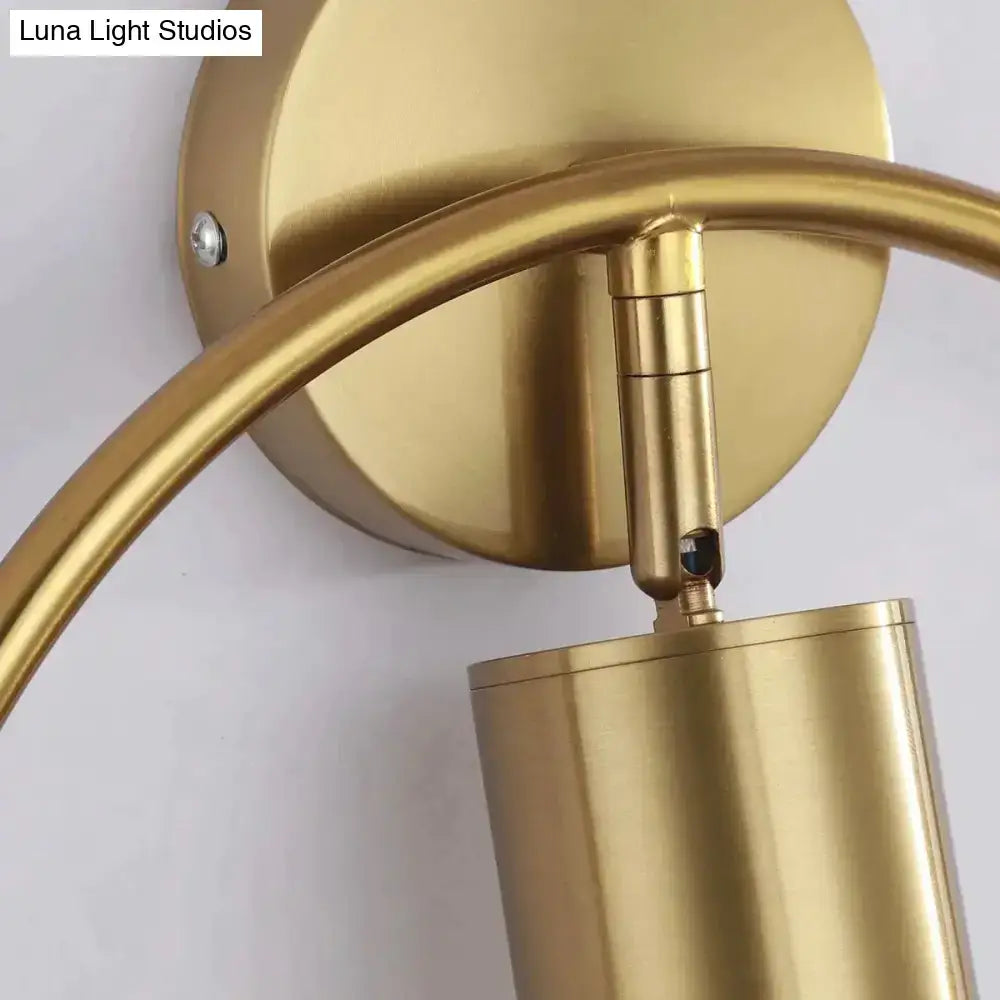 Gold-finished brass irwin wall lamp with curved arm and cylindrical shade for modern bedroom wall sconce lighting