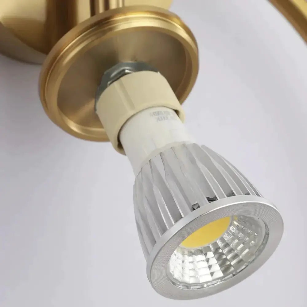 Modern black and gold irwin wall lamp with sleek silver led spotlight bulb and ribbed heat sink design for bedroom sconce