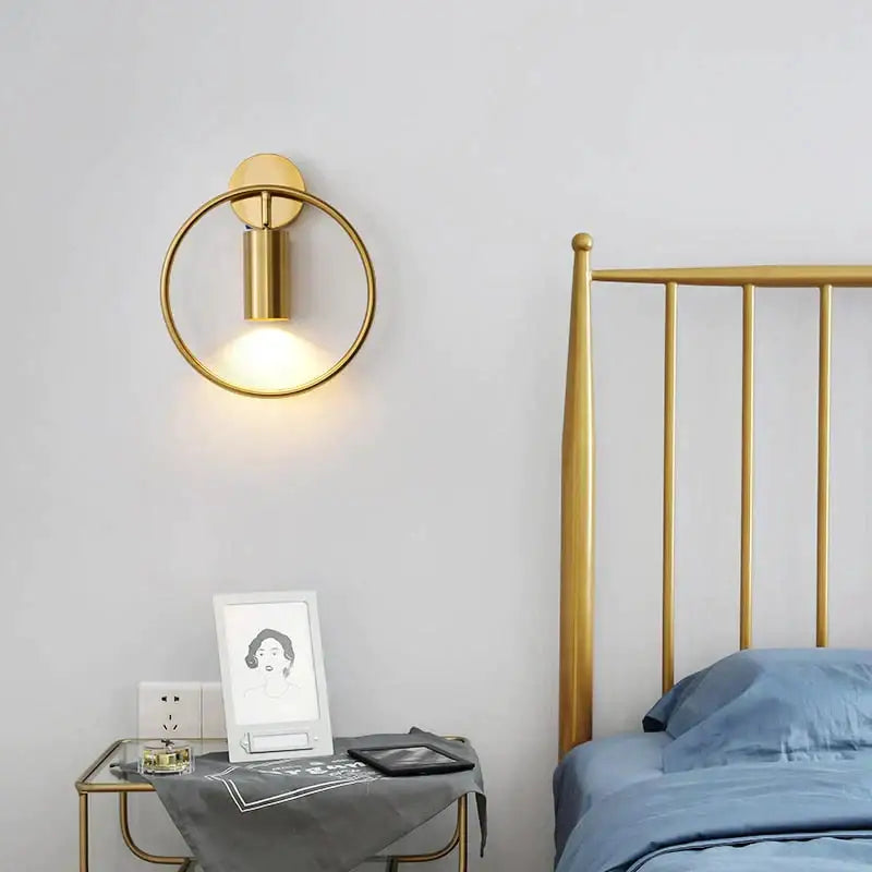 Modern black and gold irwin wall lamp featuring a gold-toned circular sconce with a cylindrical light fixture