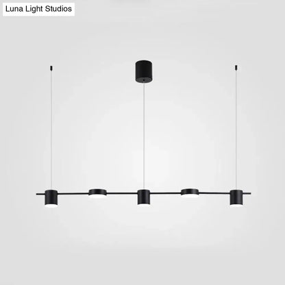 Modern black and gold ceiling light fixture featuring four minimalist cylindrical pendants for kitchen island lighting